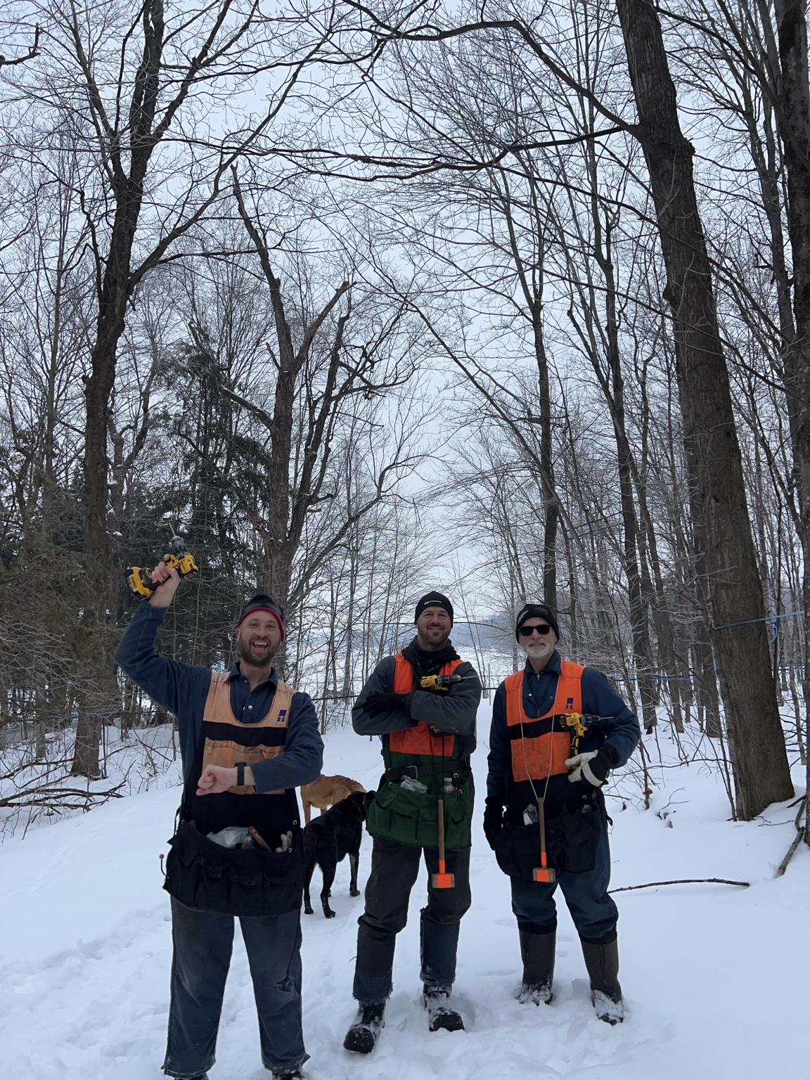 Une équipe de trois personnes dans l’érablière enneigée.